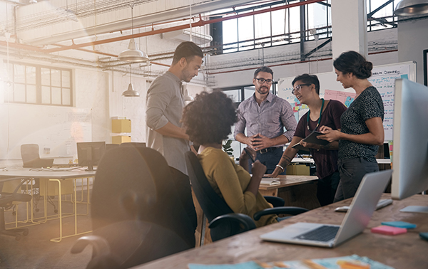 Colleagues having a discussion around a desk