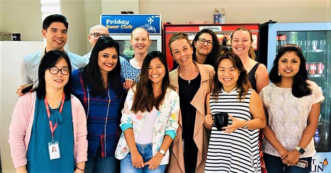 Elaine standing with ten coworkers